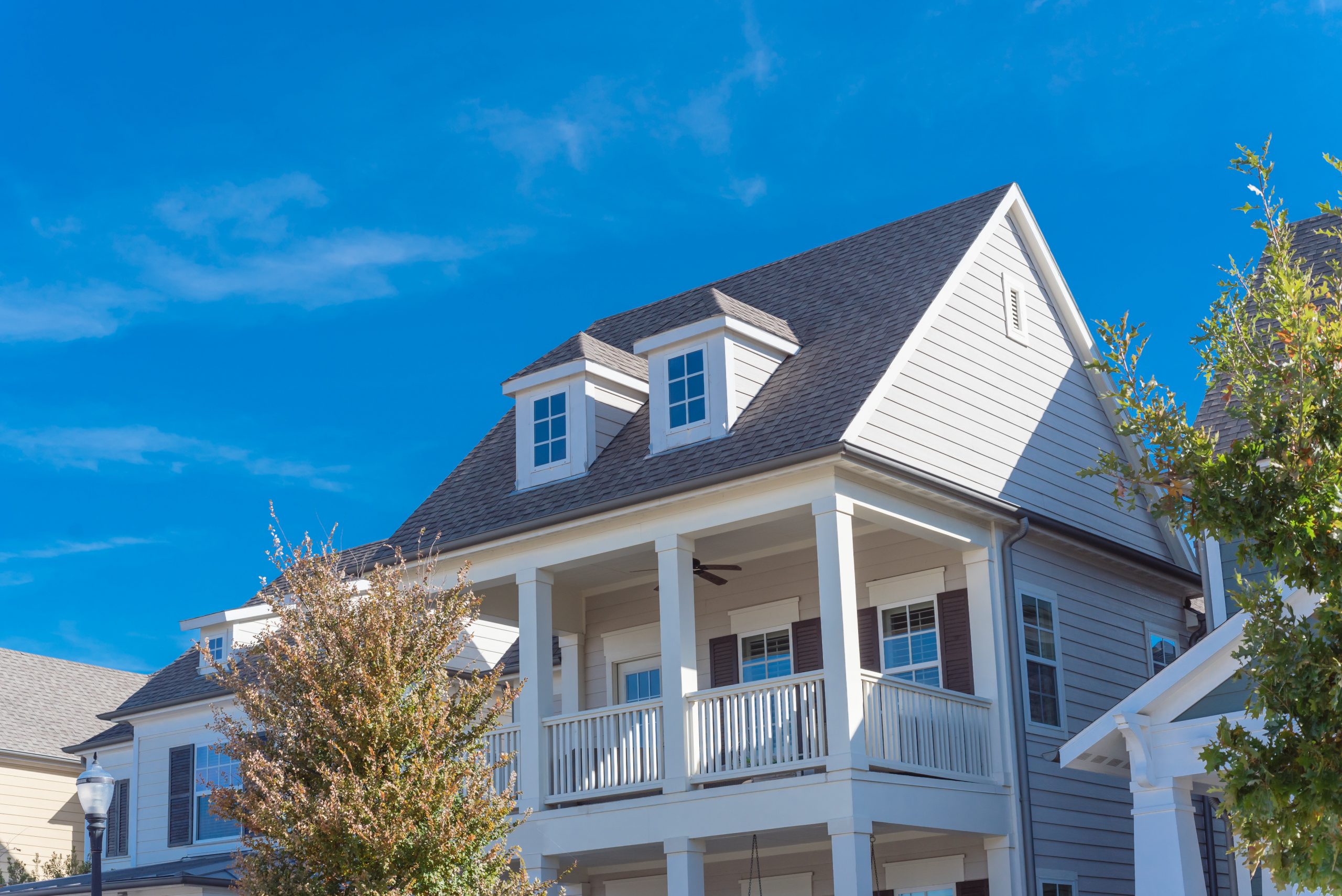 White painted porch with banister and dormer roof of two story houses near Dallas, Texas