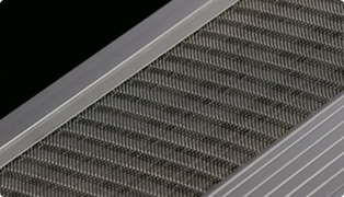 A close-up view of a metallic air filter grille with parallel slats and a fine mesh pattern, set in a diagonal orientation against a black background.